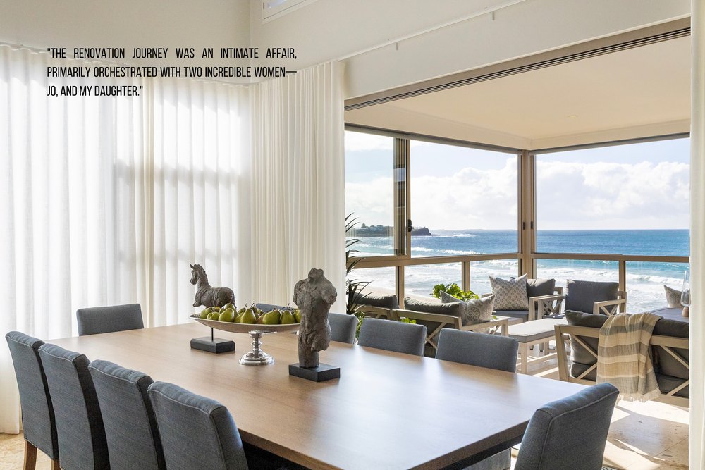 Book page: a dining table beside sheer curtains and an ocean view
